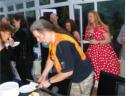 John cuts more cake, deferring to a knife after cutting himself with the Axe