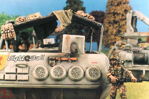 In times of less stress a Thunderbolt Division infantryman walk past a Slammers Combat Car